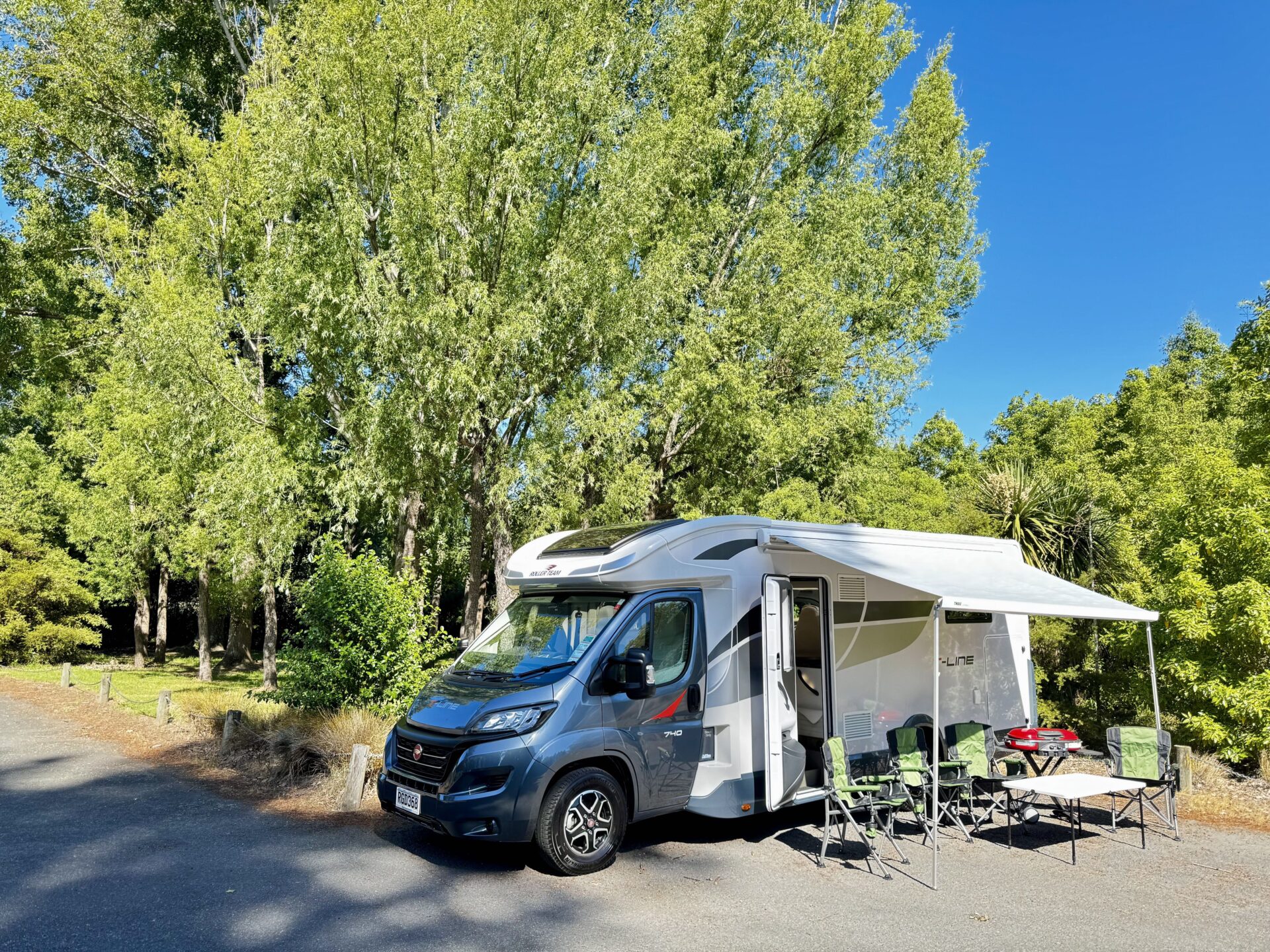 SpringLight motorhome set up with awning and outdoor chairs