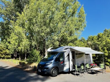 SpringLight motorhome set up with awning and outdoor chairs